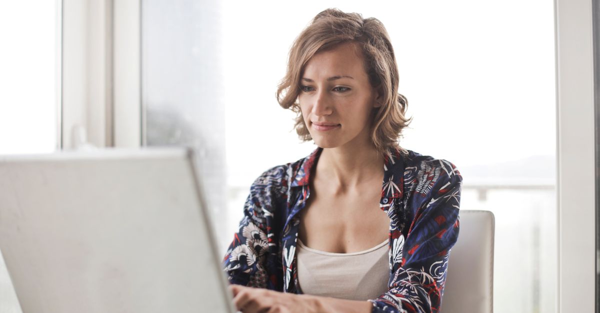 Woman working at a laptop looking drained