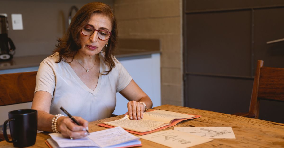 Woman writing notes at a desk with a coffee