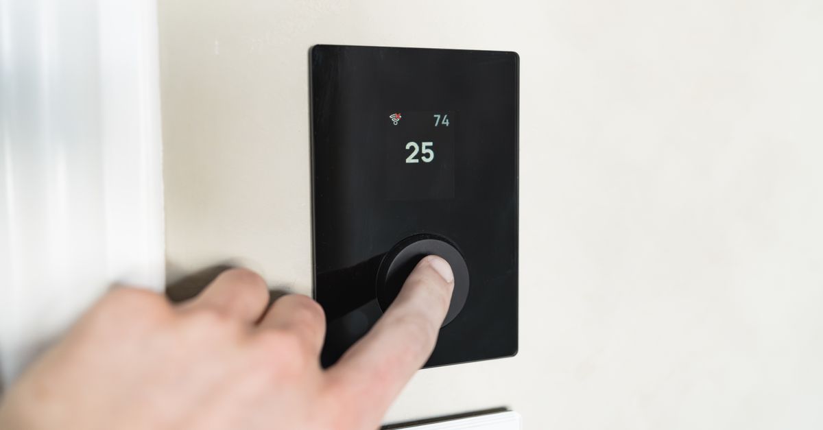 Hand adjusting a wall thermostat, the body equivalent of the narrowed band behind cold night sweats