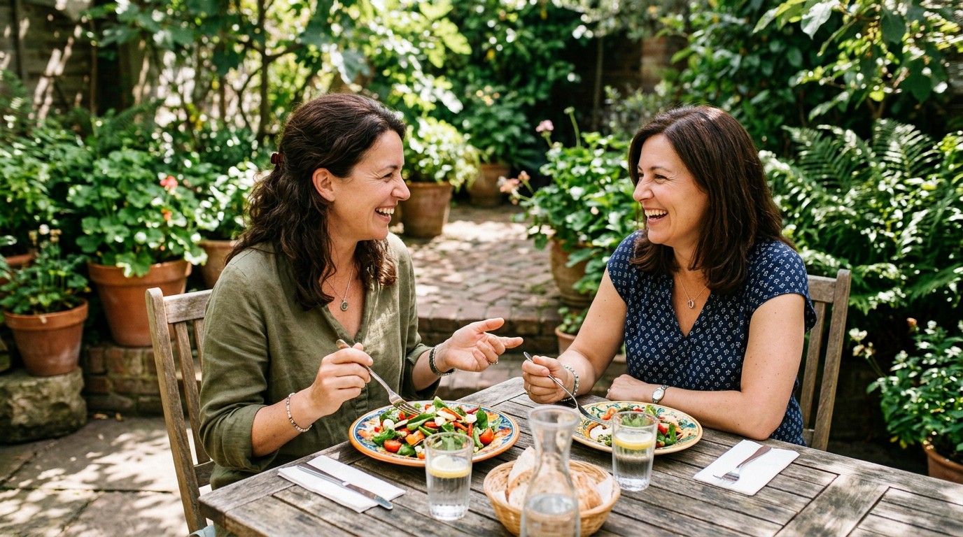Two friends sharing a healthy lunch while discussing their personal experiences with perimenopause and diet.